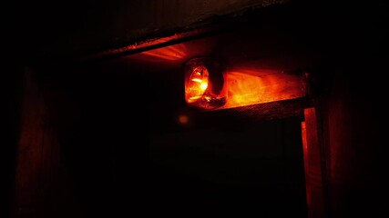 Close-up of a rotating red emergency siren lamp on the wall of a dark tunnel. A bomb shelter, an emergency signal on the wall during an air raid.
