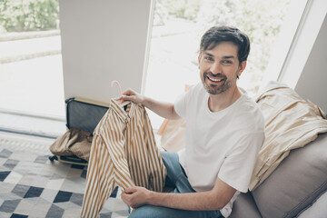 Young man choosing a shirt at home during a leisurely weekend afternoon