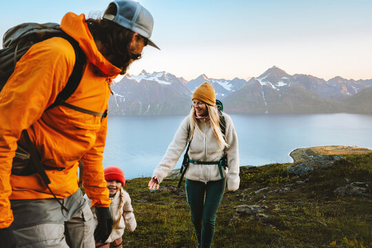 Family hiking together active travel lifestyle - mother, father, and child in mountains adventure tour in Norway, parents and kid on summer vacations outdoor, healthy lifestyle tourism, happy moments