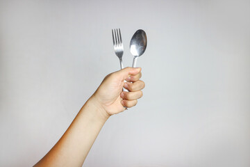 A women hand holding spoon silver stainless steel. Isolated in White Background. side View.