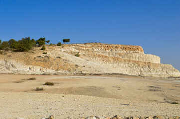 Arid Desert Quarry: Limestone Layers Under Clear Skies