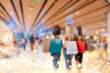 Blurry image of people shopping in a modern shopping mall in China. The image is out of focus, but the colorful shopping bags are visible.