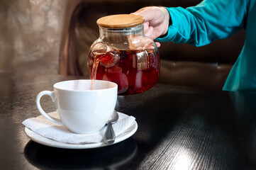 Pouring a warm tea into a cup on a cozy Thanksgiving day
