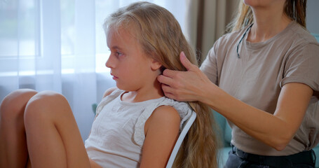 Mother Combing Daughter's Long Hair at Home, Near Window