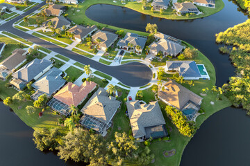 Upscale suburban homes at sunset with large backyards and green grassy lawns. Private residential...