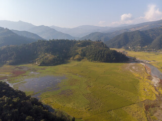 Scenic aerial view of a lush valley surrounded by mountains.