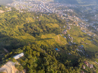 Aerial view of terraced fields and a small town nestled in a lush green valley