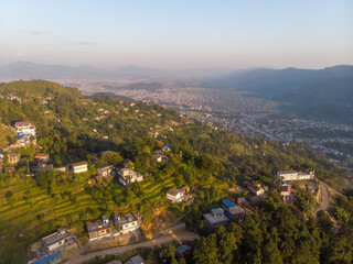 Scenic aerial view of a hillside village with a backdrop of a sprawling valley and distant...