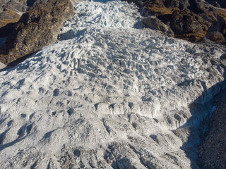 Aerial view of a rugged glacier nestled between rocky terrain.