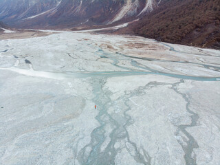 A vast, rugged landscape with winding rivers meandering through a barren valley surrounded by...
