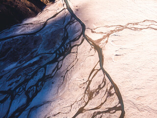 Aerial view of a vast frozen landscape with intersecting rivers and shadows.