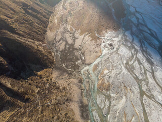 Aerial view of a mountainous landscape with a partially frozen river.