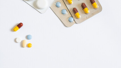 Pile of colorful medicine pills and capsules in blister packs.