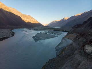 A serene twilight view over a winding river through a mountainous valley.