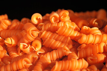 Nahaufnahme Nudel aus roten Linsen auf schwarzem Hintergrund