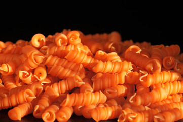 Nahaufnahme Nudel aus roten Linsen auf schwarzem Hintergrund