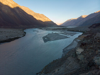 Serene river flowing through a mountainous valley at dusk