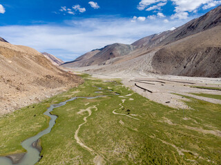 A serene river valley nestled between mountain slopes under a clear sky
