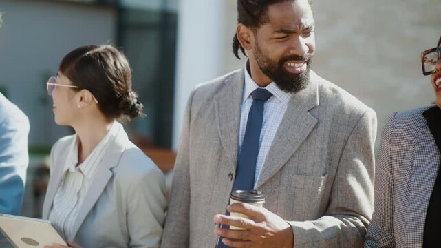 Multi-ethnic businesspersons spending their coffe break time enjoying talking and walking outdoor