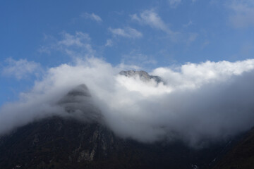 Mist-covered mountain peaks under a clear blue sky.
