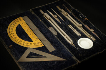 Antique stationery set featuring a compass, ruler, square, and protractor, beautifully arranged on...