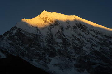 A majestic snow-capped mountain peak at sunset.