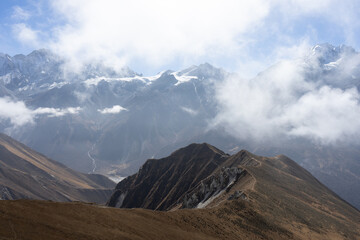 A breathtaking view of a mountain range shrouded in mist and clouds.