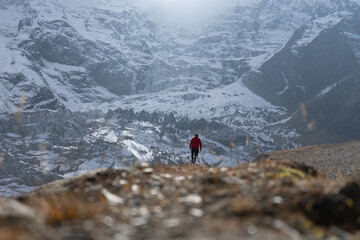 A lone hiker traversing a snowy mountain landscape