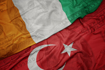 waving colorful flag of ivory coast and national flag of turkey on the dollar money background....
