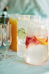 Jug, fruit water and home for beverage hydration, nutrition and table setup for celebration. Drink, glass and decoration and special event for festive arrangement, holiday catering and detox liquid