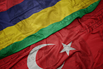 waving colorful flag of mauritius and national flag of turkey on the dollar money background. finance concept.