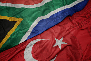 waving colorful flag of south africa and national flag of turkey on the dollar money background....