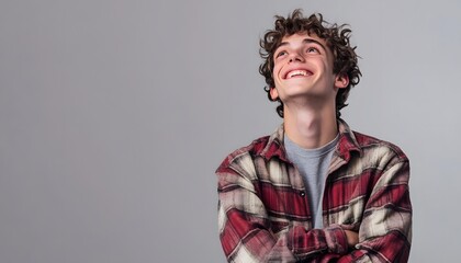 Smiling Young Man Looking Up with Crossed Arms