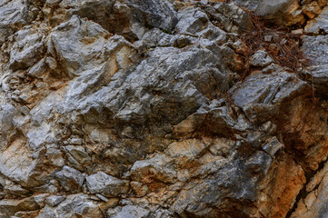 Natural rocky surface showcasing various textures and colors in a mountainous region during daylight hours