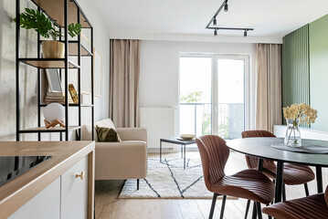 Dining room with living room with window in new apartment. Modern interior with chairs with table and white furniture at home. Design architecture.	