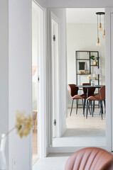 Dining room with table and brown chair in new apartment. Modern interior with stylish furniture at home. Design indoors architecture in hotel. Vertical.
