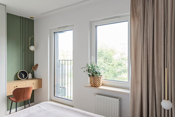 Fototapeta premium Modern interior of a house with bright bedroom with window, wooden table with chair and design furniture. Monimalism style in indoors rachitecture in new apartment. Room hotel.