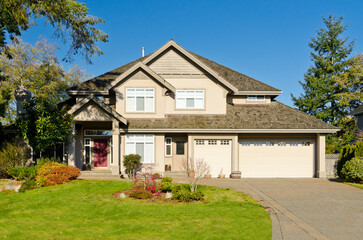 luxury house with garage door, big tree and nice Fall Foliage landscape in Vancouver, Canada