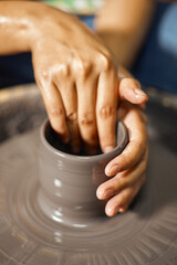 Hands of craftsman artist working on pottery wheel