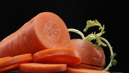 Macrography, sliced carrots take center stage with black background, creating a striking visual contrast. Each close-up shot capture the intricate details and vibrant colors of the carrot. Comestible.