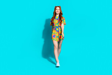 Full length photo of lovely young lady walking dressed stylish colorful garment isolated on cyan color background