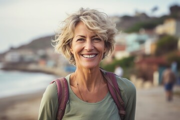 Portrait of a smiling woman in her 50s sporting a breathable hiking shirt isolated on bustling beach resort background