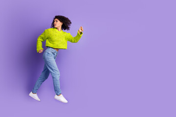 Full length photo of lovely young lady running turn around scared dressed stylish green garment isolated on violet color background