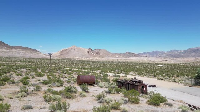 Rusty train and barrel in ghost town. Aerial shot. Rhyolite, Nevada, USA. 