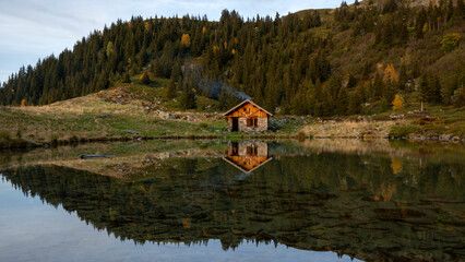 Obraz premium Paysage de montagne dans le massif de Belledonne entre alpages et forêts autour du lac de Léat en automne dans les Alpes