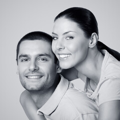 Monochrome b w image - happy smile young couple. Portrait of hugging boyfriend, girlfriend, lovers - Valentine day studio concept, isolate on plain background. Brunette man and woman together. Square.