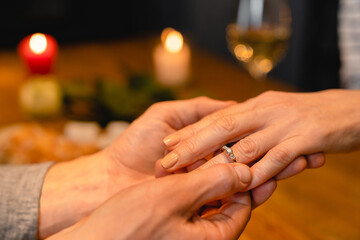 Close up photo of engagement ring on woman`s hand during a date. New family, proposal, diamond...