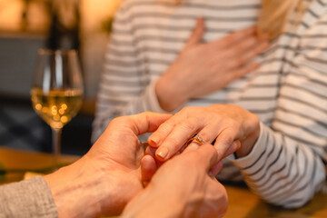 Impressed by the proposal woman in the background with her hand and engagement ring on a date....