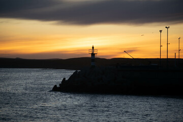 Aatardecer en el Puerto de Camarones, en la Patagonia Argentina, provincia de Chubut, donde se puede apreciar el característico faro. 