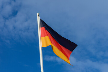Waving German flag under a clear blue sky on a sunny day